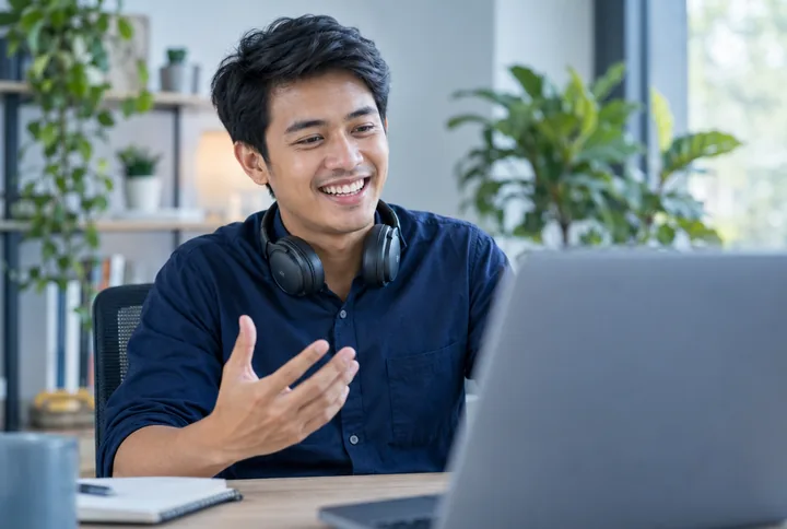 A smiling recruiter speaking to someone on a laptop